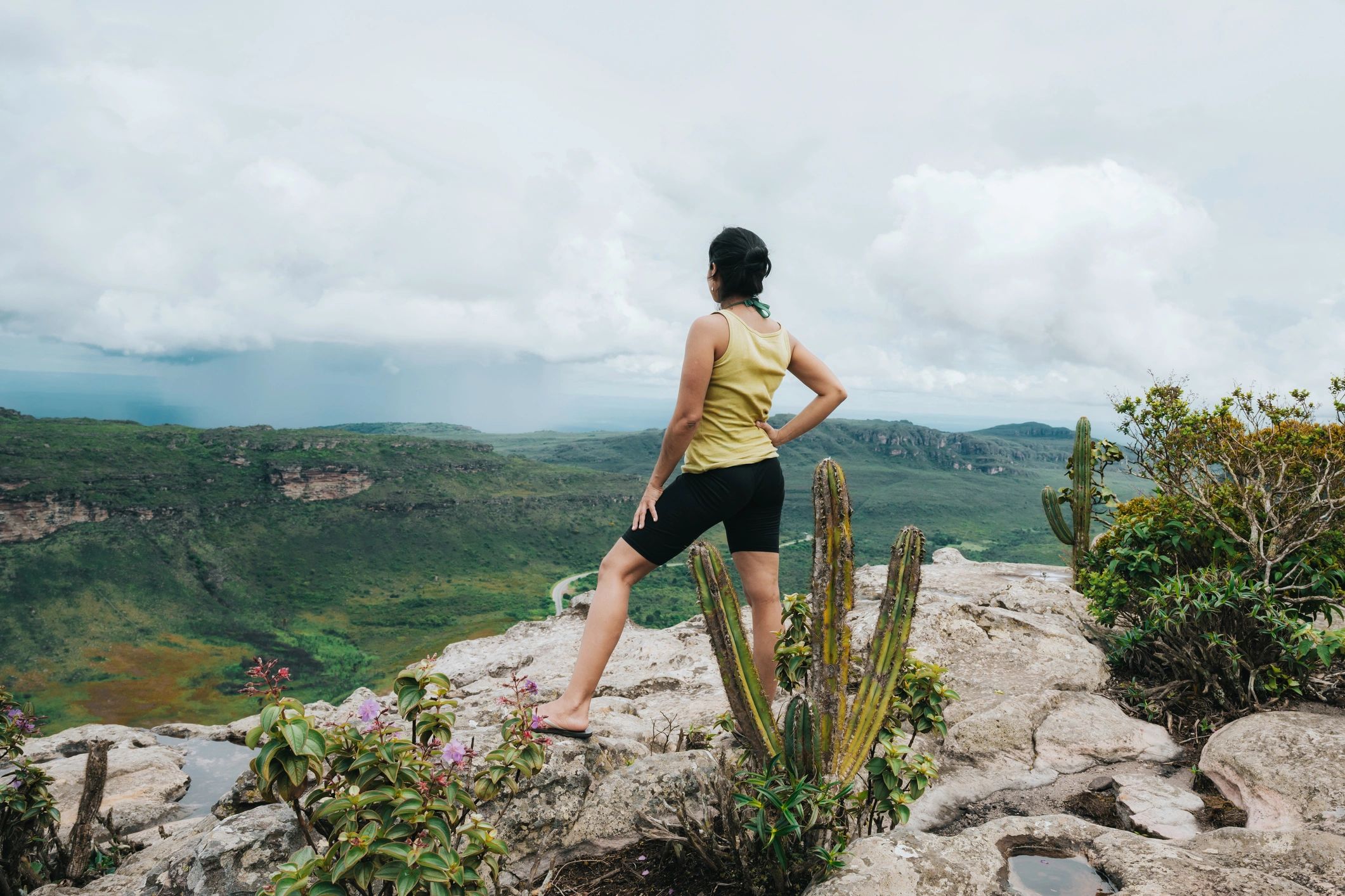 Person standing on a rocky ridge overlooking mountain highlands