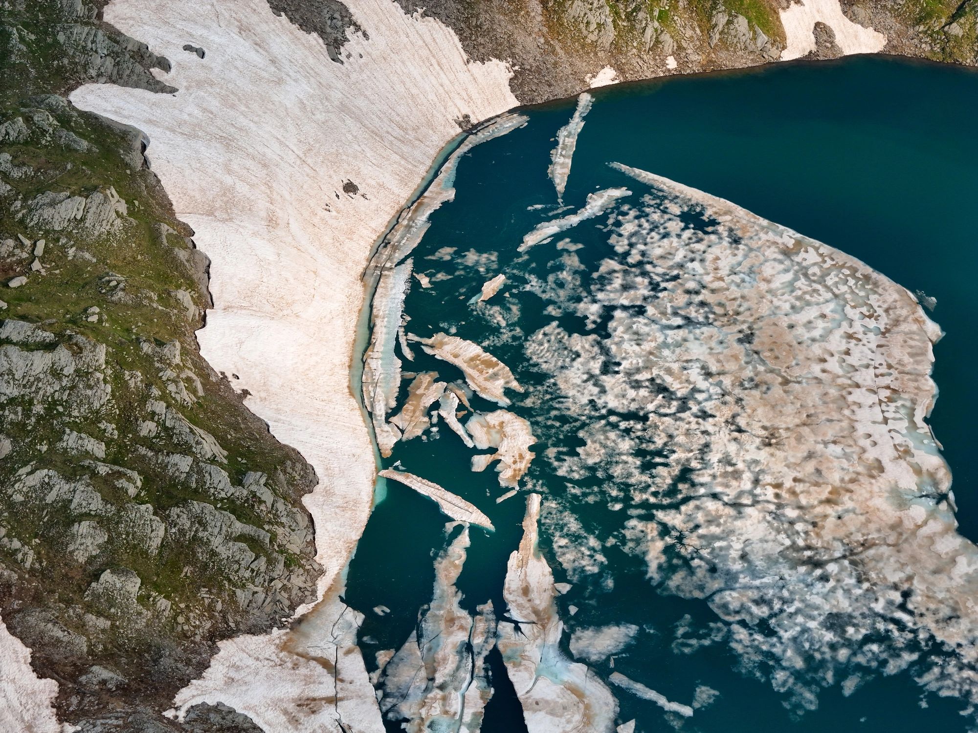 Aerial view of glacial ice in a turquoise mountain lake